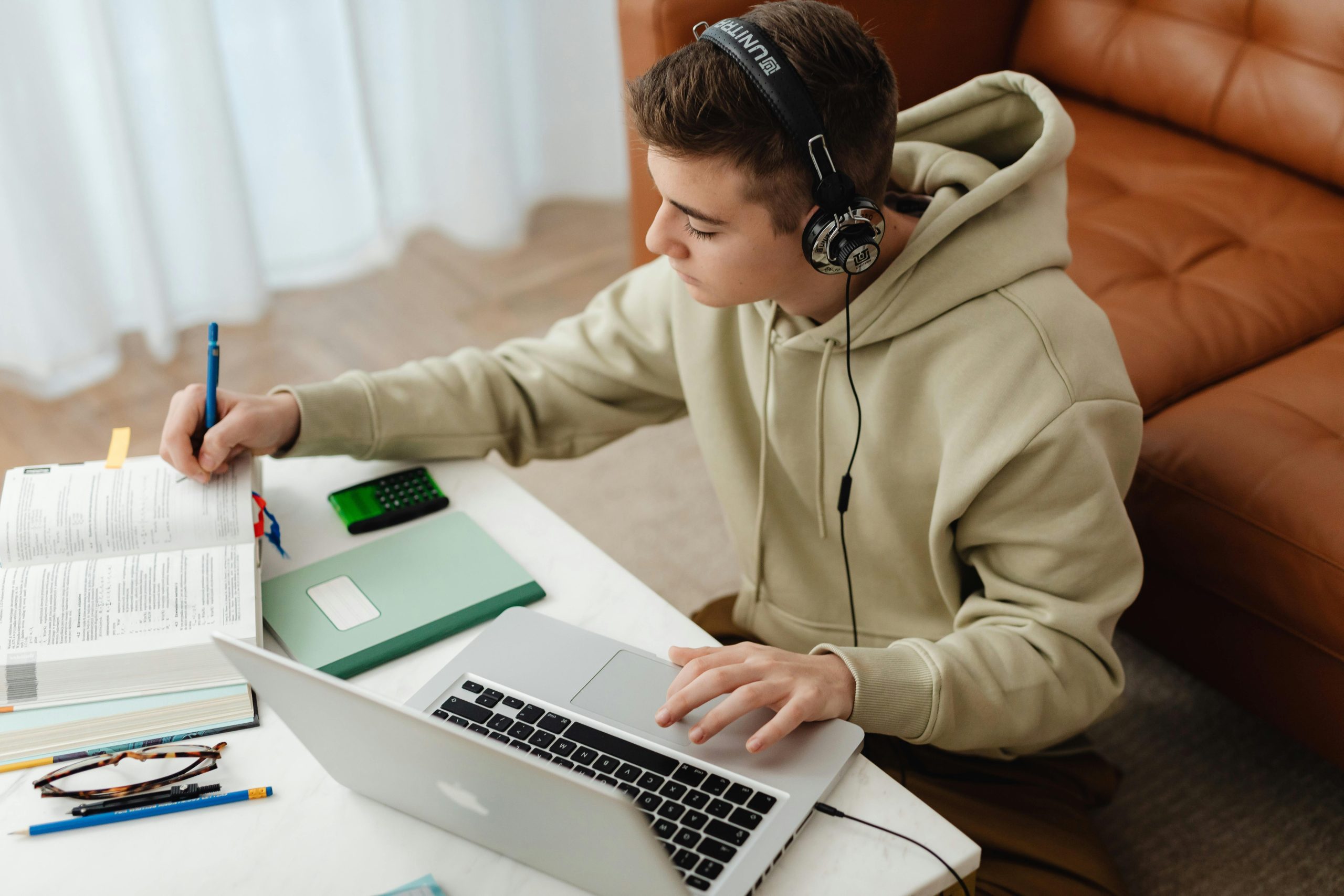 Teen working with a book and laptop